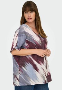 T-shirt ample à col en V dans un motif mixte de bordeaux, bleu et crème, avec des manches courtes et un tissu texturé.