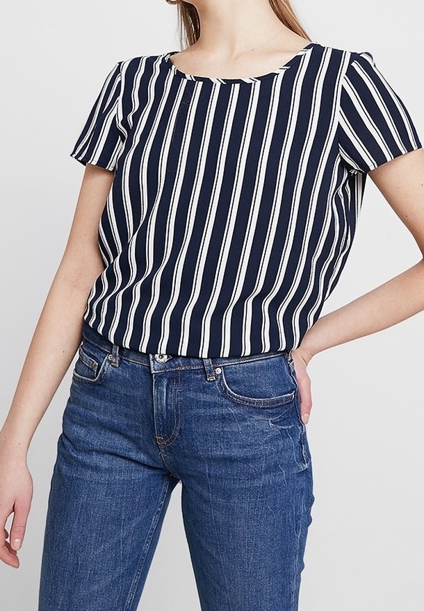 Marineblauw en witte gestreepte korte mouwen top met een ronde hals; gecombineerd met blauwe jeans, met een ontspannen pasvorm en een soepele stoftextuur.