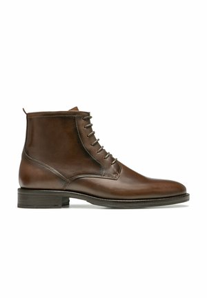 Bottines en cuir marron avec une finition lisse, bout rond et un laçage à cinq œillets. Présente une languette au talon et un talon bas empilé.