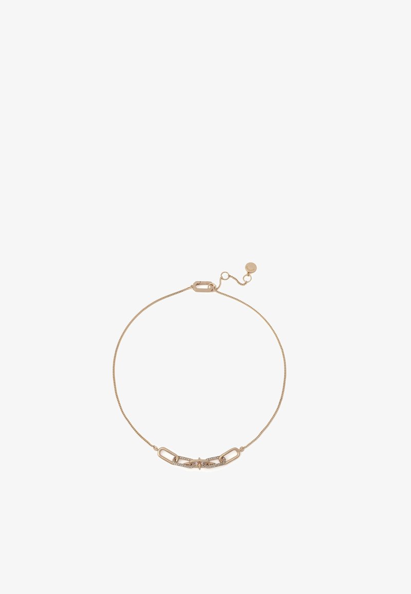 Bracelet ton or avec un design de chaîne délicate. Le maillon central présente trois petites pierres claires. Fermoir ajustable à une extrémité.