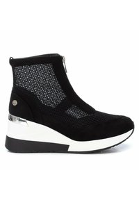 Botín negro hasta el tobillo con paneles de malla, cierre de cremallera, tacón en cuña y suela blanca. Presenta una textura de ante suave y un detalle decorativo de hardware.