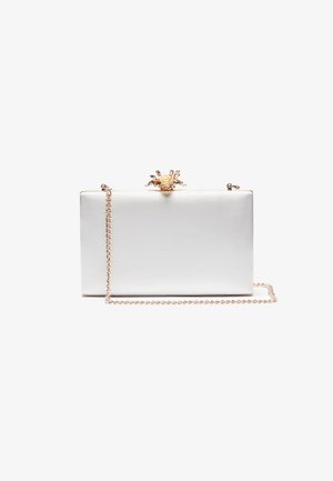 Vitt satin clutch med ett gulddekorerat spänne som liknar en krona, rektangulär form och en kedjesnor. Slät textur med metalliska accenter.