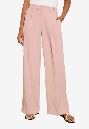 Lichtroze wijde broek met plooien, textuurstof, zijzakken en een aansluitende tailleband, gedragen met zwarte sandalen.