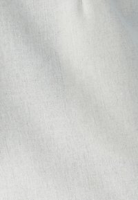 Leinenstoff in Off-White mit einer strukturierten Oberfläche und einem dezenten Webmuster. Leicht zerknittertes Aussehen verleiht Tiefe.