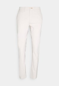 Pantalones ajustados de color blanco roto con cierre de botón y cremallera, trabillas para cinturón y bolsillos laterales y para monedas, exhibidos sobre un fondo liso.