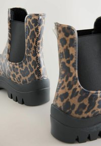 Leopardimustriga vihmamustrid läikiva viimistlusega, mustad elastsed küljed ja karm must tallaosa haarduvuse tagamiseks. Omavad paksemat kontsa.