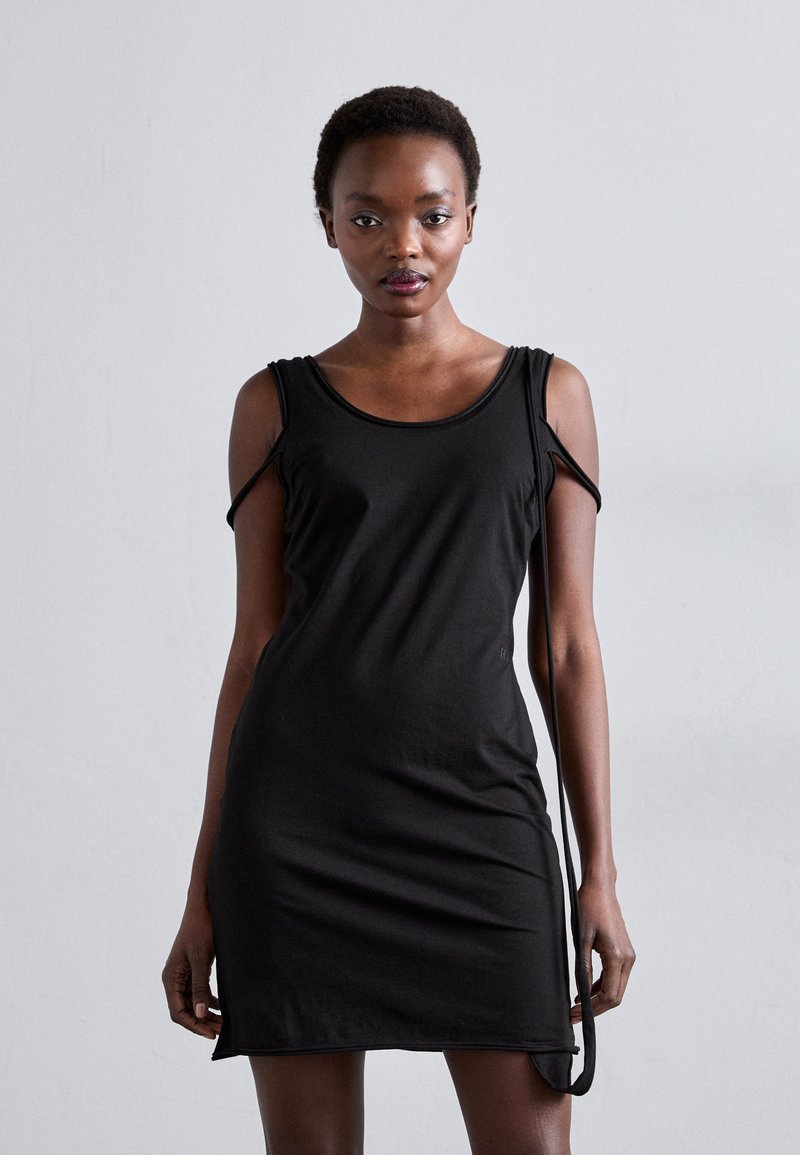 Fekete, ujjatlan ruha puha anyagból, kerek nyakkivágással és kivágott részlettekkel a vállaknál. Egyszerű, testhez simuló fazon.