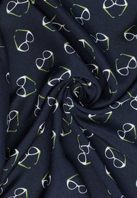 Marineblauer Stoff mit einem wiederholten Muster aus weiß gerahmten Brillen mit grünen Akzenten, der eine glatte Textur und ein leichtes Design aufweist.