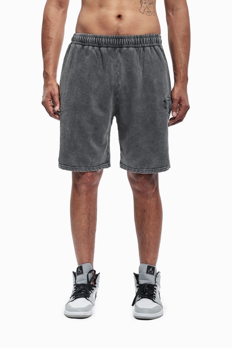 Grå shorts med elastisk linning, som har sidelommer og en teksturert overflate. Kombinert med svarte og grå høye sneakers.