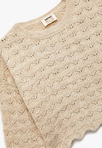 Beżowy sweter dziany z teksturowanym wzorem fal, z okrągłym dekoltem i miękkiego materiału. Etykieta widoczna wewnątrz kołnierza.