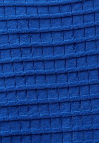 Tissu tricoté bleu avec des lignes côtelées horizontales et verticales formant un motif de grille texturé.