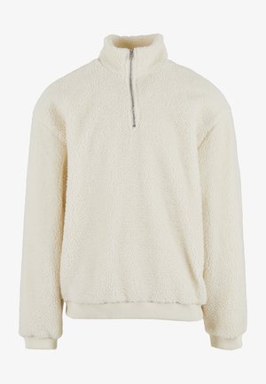 Krēmkrāsas vilnas džemperis ar augstu apkakli, pusērlējas aizdari un ribotiem aprocēm. Piedāvā mīkstu, teksturētu virsmu un ērtu piegriezumu.