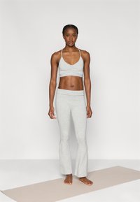 Σετ αθλητικών ρούχων ανοιχτού γκρι με αθλητικό μπουστάκι κοντό με λαιμόκοψη σε σχήμα V και παντελόνι καμπάνα που ταιριάζει, κατασκευασμένο από απαλό, ελαστικό ύφασμα.