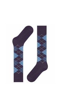 Due calze esposte: una calza viola con un motivo argyle in diverse tonalità di blu e bianco, caratterizzata da forme a diamante e disegni contrastanti.