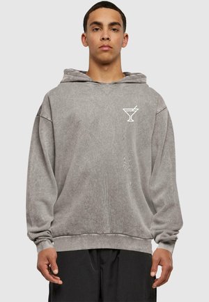 Grå bomulds hoodie med snor, oversized pasform, ribbede manchetter og kant, med et hvidt martini glas grafik på brystet.
