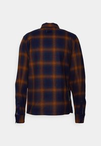 Mans rutiga skjorta i marinblått och orange, med knäppbar krage, långa ärmar och en mjuk struktur med ett rutig mönster.