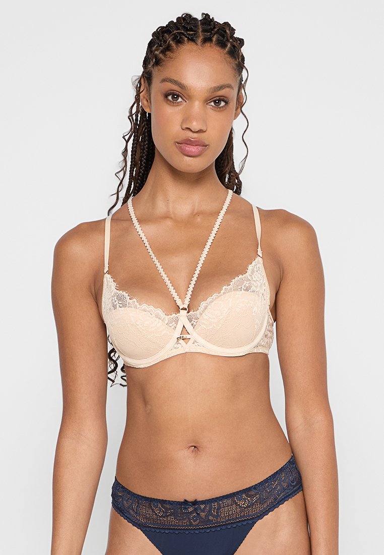 Lace covert padded bh in nude, met een geometrisch ontwerp, verstelbare schouderbanden en een decoratieve centrale accentuering.