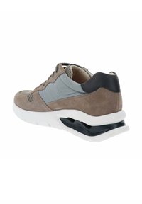 Zapato de hombre con un upper de ante marrón claro, acentos grises, detalles de malla, entresuela blanca y un talón negro con un compartimento de aire visible.