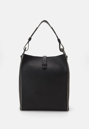 Sac à main en cuir noir avec une forme structurée, bandoulière ajustable et poignée supérieure. Présente une grande fermeture éclair sur un côté.