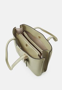 Zelená kožená taška přes rameno s texturovaným povrchem, zdobená zlatým kováním, se dvěma vnitřními odděleními a kapsou na zip.