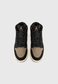 Ténis altos feitos de pele preta e camurça, com biqueira castanha, detalhes perfurados e sola de borracha contrastante.