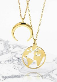 Collares de oro con un colgante de luna creciente y un colgante de globo terráqueo, ambos con intrincados diseños recortados, colgando de cadenas delgadas.