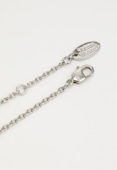 Ασημένια μεταλλική αλυσίδα με διασυνδεδεμένους κρίκους, κούμπωμα αχιβάδας και οβάλ ετικέτα χαραγμένη με λεπτομέρειες της μάρκας. Λείος υφή σε όλη την επιφάνεια.
