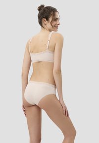 Beiges Spitzenunterwäsche-Set mit Spitzensaum, bestehend aus einem Bralette mit verstellbaren Trägern und passenden hochgeschnittenen Slips, glatte Textur.