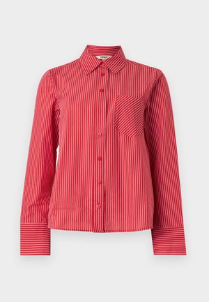 Κόκκινο πουκάμισο με λευκές κάθετες ρίγες, τσέπη στο στήθος με διαγώνιες ρίγες, μακριά μανίκια και μυτερό γιακά.