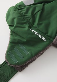 Green outdoor hat with a soft gray fleece lining, featuring a stitched logo and three textured fabric accents on the side.