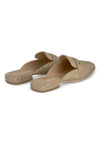 Beige Slipper mit flacher Sohle, verziert mit kleinen dekorativen Steinen und geometrischen Mustern auf der Oberseite.