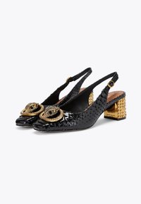 Black slingback heels with textured patent leather, featuring gold-tone accents and a decorated block heel with studded detailing.