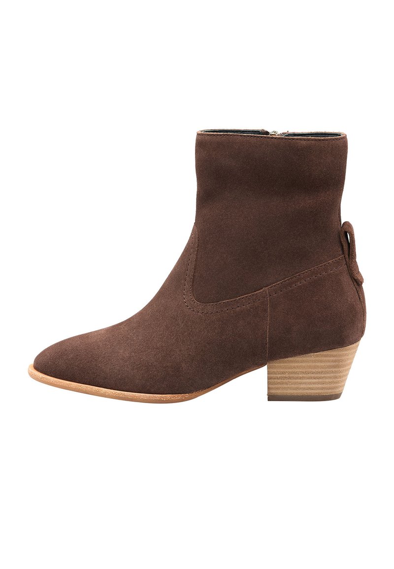 Bottines en daim marron avec un bout pointu, un petit talon empilé et un détail décoratif de boucle latérale. Texture lisse et design simple.