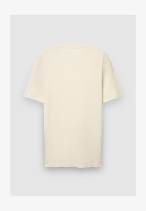T-shirt à manches courtes de couleur crème en tissu côtelé. Dispose d'un col rond et d'une coupe droite avec un ourlet net.