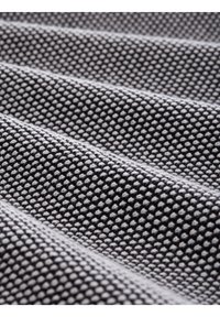 Strukturiertes Gewebe in Grau und Weiß, das ein gewebtes Muster mit erhabenen Punkten zeigt und sich in sanften Falten legt.