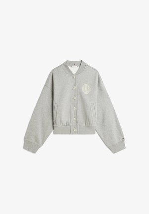 Sweat-shirt gris à boutons, manches longues, poignets et ourlet côtelés, poches latérales, et petit logo "Hilfiger" sur la poitrine et la manche.