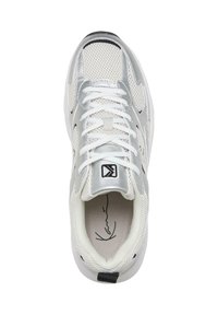 Bijele mrežaste tenisice sa srebrnim akcentima, okrugli nos, vezanje na vezice, podstavljena ovratnik i crni logo na jeziku. Unutrašnjost sadrži potpisani dizajn.