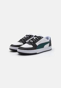 Black and white sneakers med grønne accenter. Har perforeret hvid lædertå, sorte lædersider, hvid sål og sorte snørebånd.