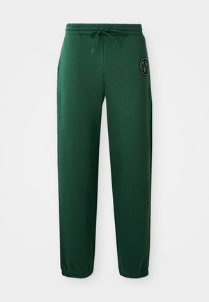Grüne Jogginghosen aus Baumwollmischung, mit einem elastischen Bund und Kordelzug, Seitentaschen und einem runden Logo am linken Oberschenkel.