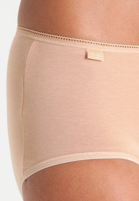 Beige bomullsstringtruse med en myk tekstur, med en delikat blondekant ved midjen og et lite merkelapp på siden.