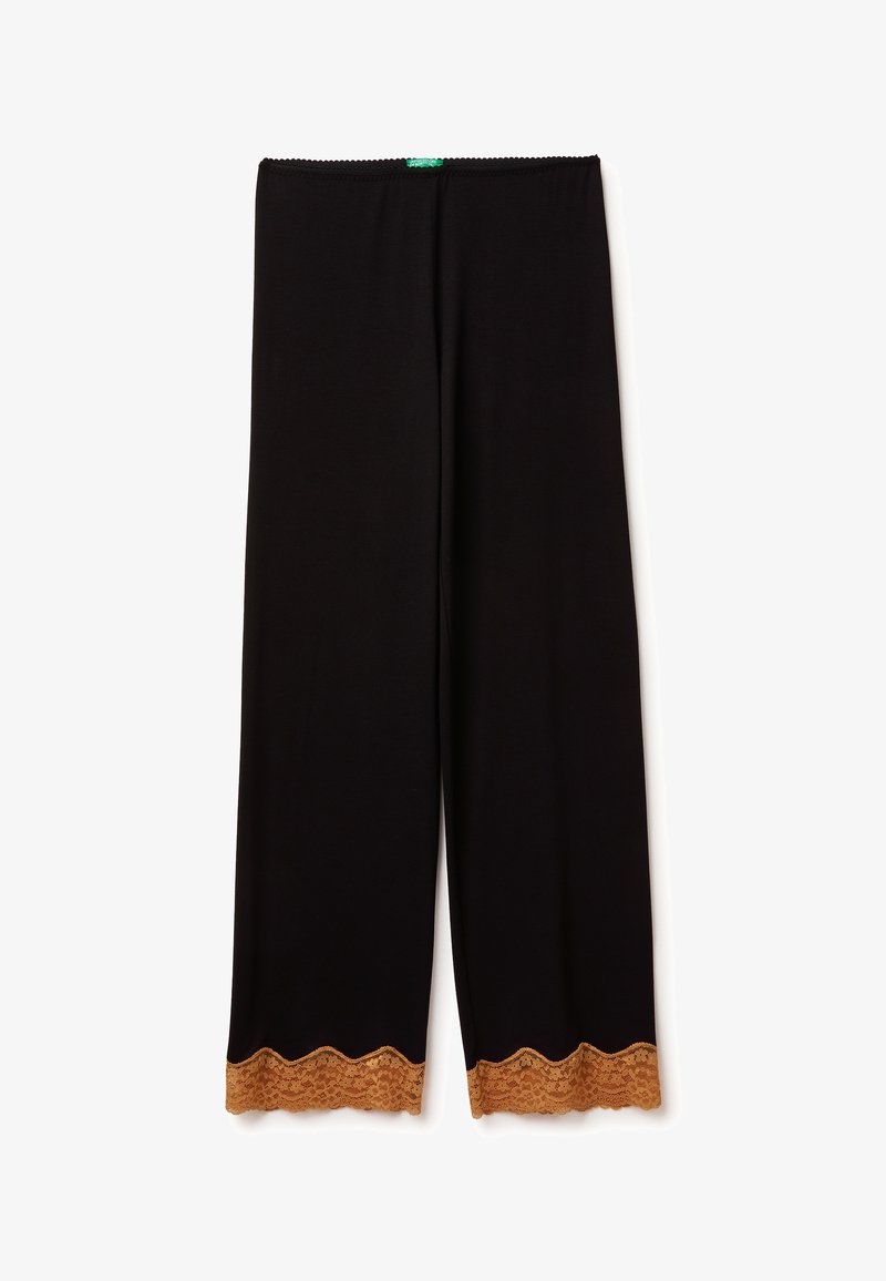 Schwarze Leggings mit einem gewellten Saum, die mit einem Spitzenakzent in einem hellbraunen Farbton versehen sind. Dehnbare Stoff mit einer glatten Textur.