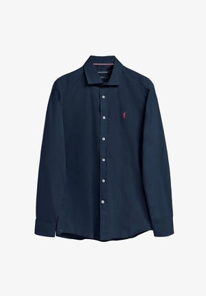 Chemise à manches longues bleu marine en coton avec un col boutonné, comportant un petit logo rouge brodé, des boutons blancs et des fentes sur les côtés.