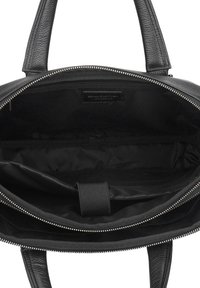 Zwarte leren totebag met een gestructureerde afwerking, voorzien van een ritssluiting bovenaan en meerdere binnenvakken. Gevoerd met zwarte stof.