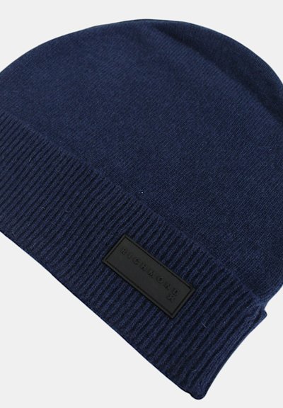 Berretto lavorato a maglia di colore blu navy realizzato in un tessuto morbido, con una texture a coste e una patch rettangolare in pelle nera con lettering in rilievo.
