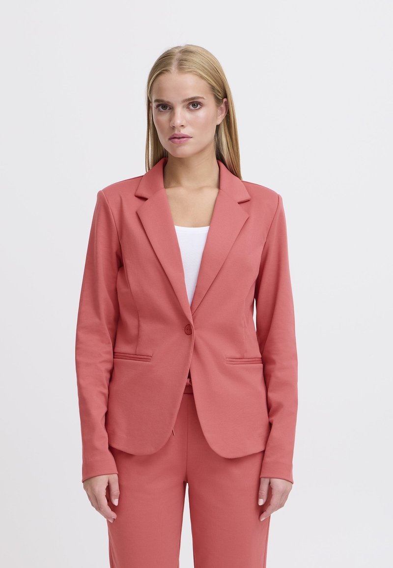 Koraalroze blazer met een geknipte revers, enkele knoopsluiting en opgestikte zakken. Soepele, rekbare stof met een getailleerde pasvorm.