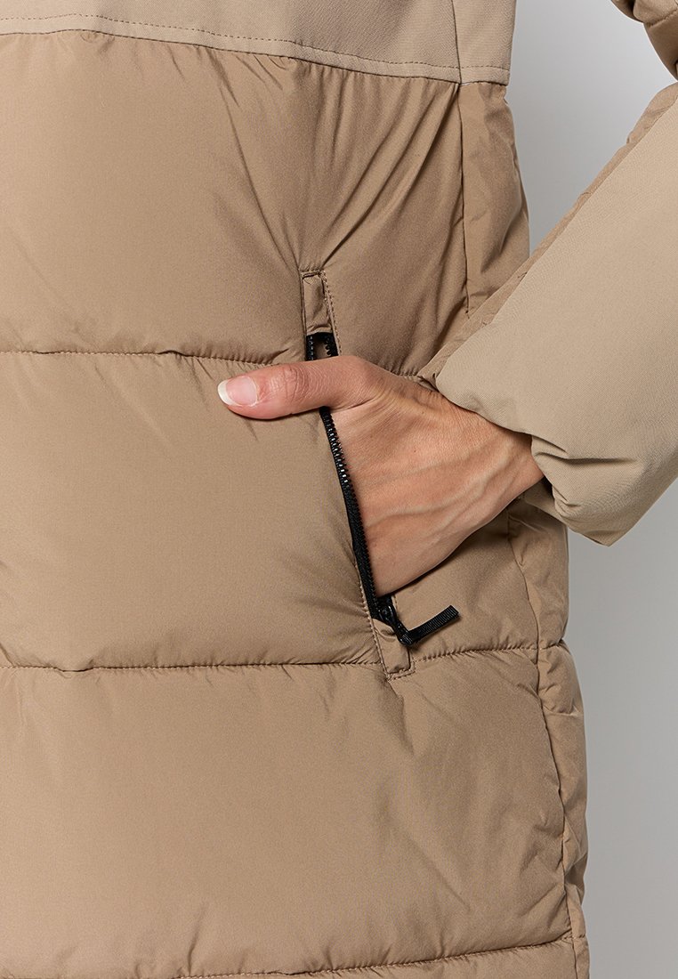 Beige gesteppte Jacke mit einer Reißverschlusstasche auf der linken Seite, glatter Textur und leicht glänzender Oberfläche sowie gesteppten Einsätzen.