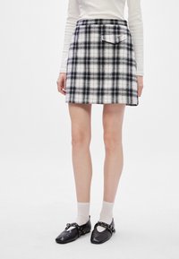 Μαύρη και άσπρη καρό μίνι φούστα από υφασμάτινη ύφανση με ψηλή μέση, διαθέτει πίσω τσέπη και ίσια σιλουέτα.