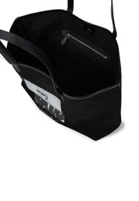 Fekete vászontáska, strukturált formával, cipzáras belső zsebbel és egy grafikai nyomattal az egyik oldalán. Simító bőrszíjak.