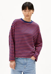 Gestreifter Sweatshirt in Marineblau und Rot, mit Rundhalsausschnitt, langen Ärmeln und lockerer Passform. Kombination mit hellen Jeans.