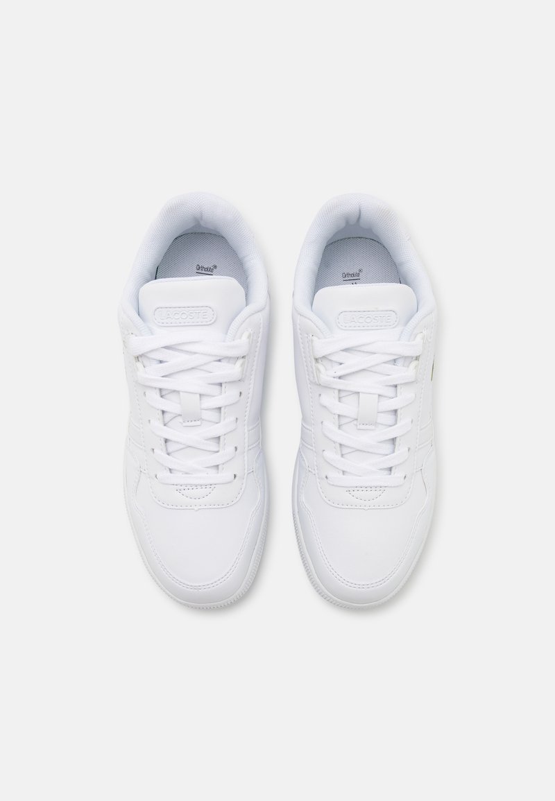 Białe sneakersy z gładką syntetyczną cholewką, okrągłym noskiem i płaskimi sznurówkami. Posiadają oznakowane język oraz wyściełany kołnierz wokół kostki.